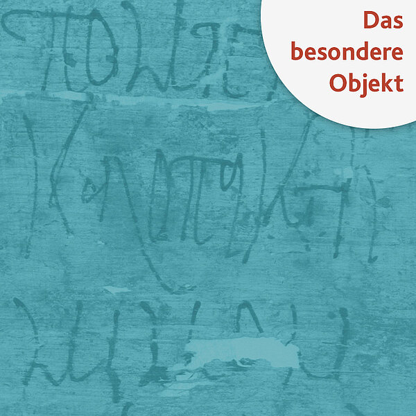 Stück Papyrus mit großer Schrift, türkis eingefärbt, im Eck steht "Das besondere Objekt"