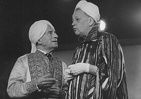 Zwei ältere Herren mit Turban und in orientalischen Gewändern unterhalten sich.