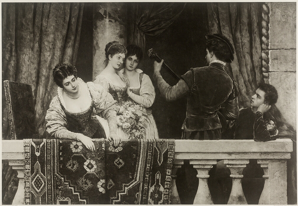 Schwarz-Weiß-Foto, das mehrere Menschen auf einem Balkon zeigt, während des Karnevals von Venedig im Jahr 1889.