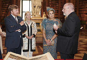 Vier elegant gekleidete Personen im Gespräch miteinander im Prunksaal.