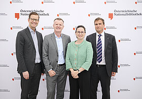 Vier Menschen posieren für ein Foto.