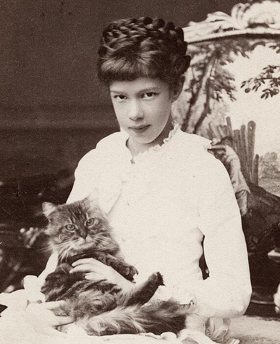 Schwarz-weißes Foto von junger Person mit Katze auf dem Schoß.