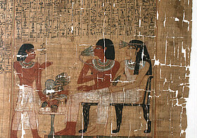 Zeichnung auf Papyrus von zwei Personen an gedecktem Esstisch, daneben steht eine weitere Person.