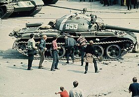 Junge Männer bewerfen ein Panzerfahrzeug mit Pflastersteinen.