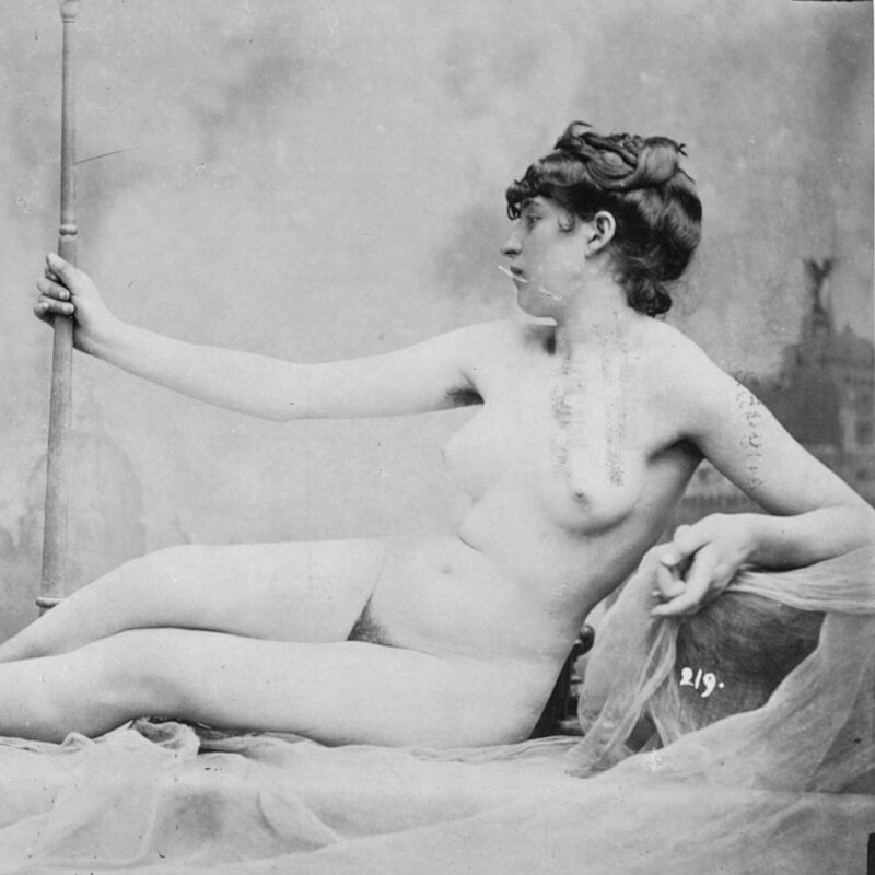 Frau posiert nackt wie eine griechische Göttin auf einem Sofa