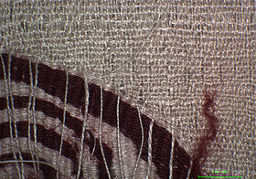 Textil aus der Nähe, rote Spirale auf Weiß.