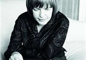 Ingeborg Bachmann vor einem Schachbrett, blickt darauf hinunter, ihre rechte Hand an einer Figur