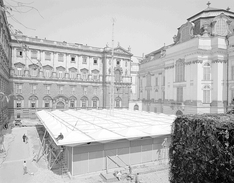 Eckige Bauten vor altmodischem Gebäude, schwarz-weiß