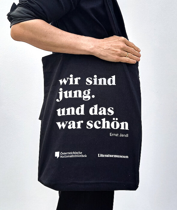 Foto von Person die schwarze Tragetasche trägt mit Text "Wir sind jung. und das war schön".