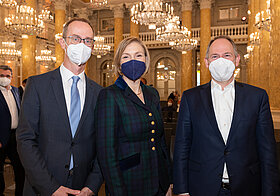 Foto von drei Personen in Anzügen. 
