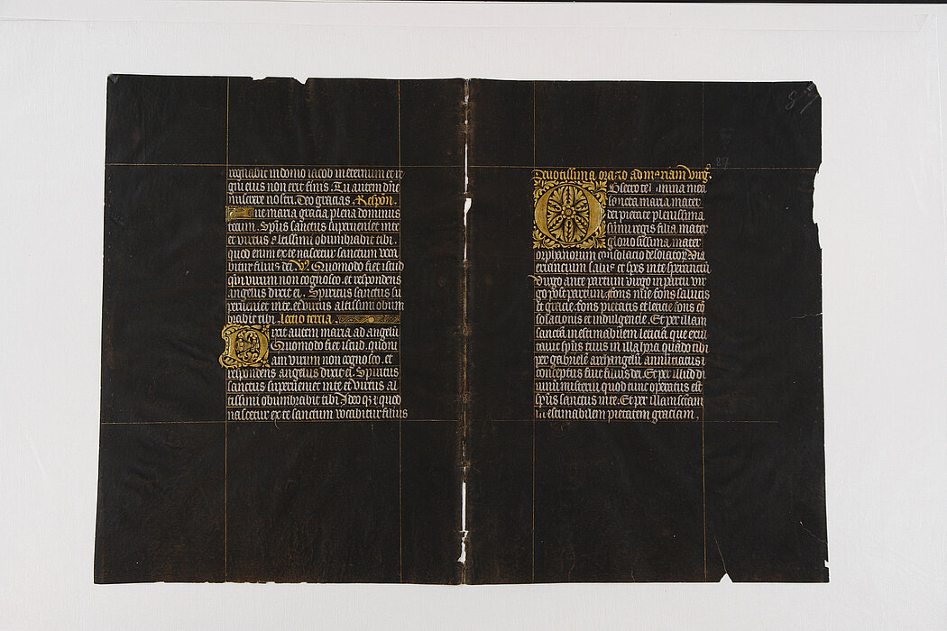 Schwarzes Pergament mit goldener und silberner Schrift. 
