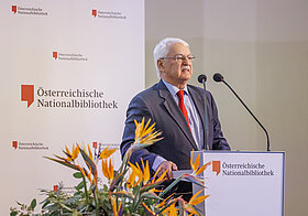 Person auf Bühne spricht in Mikro.