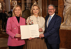 Drei Personen posieren für ein Foto. 