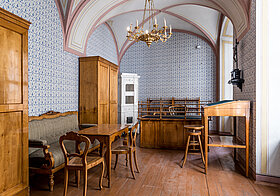 Biedermeierzimmer mit hellbraunem Möblen und blau-weiß gemusterten Wänden