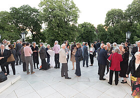 Viele elegant gekleidete Menschen auf der Burggarten-Terrasse.