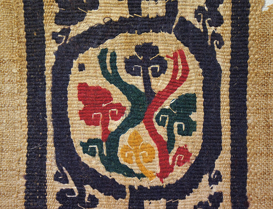 Buntes Gewebe auf bräunlichem Textil.