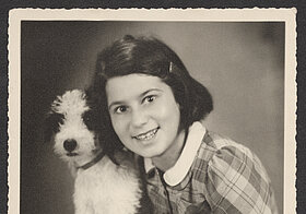 Girl in plaid dress posing with a dog