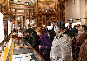 Ausstellungspublikum betrachtet eine Glasvitrine im Marmorsaal.