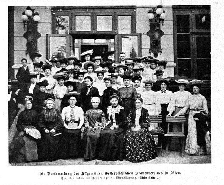 Eine große Gruppe von Frauen posiert vor einem Gebäude, schwarz-weiß