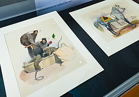 Glasvitrine mit Illustrationen von Affen und Pferd.