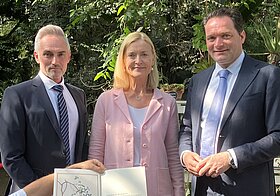Drei Personen posieren für ein Foto. 