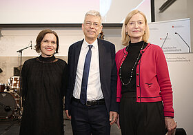 Drei Personen posieren für ein Foto. 