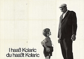 Plakat mit einem Kind und einem großen Erwachsenen, die sich ansehen. Text: I haaß Kolaric, du haaßt Kolaric. Warum sogns' zu dir Tschusch?