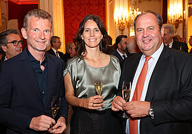 Drei Personen auf Event mit Sekt