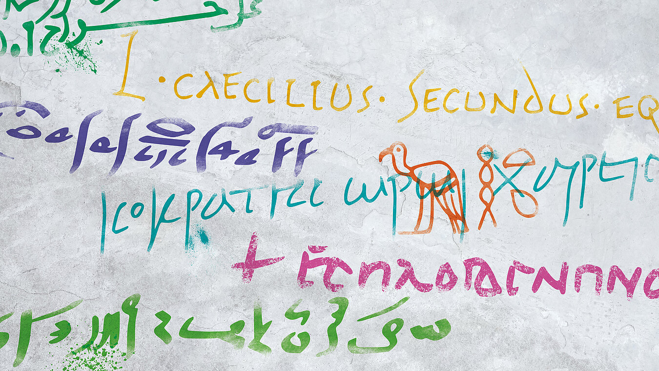 Wand mit Grafitti in verschiedenen Sprachen, z.B. in Hieroglyphen