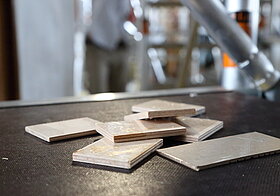 Mehrere rechteckige Holzblätter liegen auf einem Gerüst.