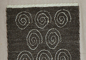 Schwarzes Gewebe mit weißen Spiralen.