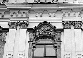 Schwarz-weißes Foto von einer Reihe an Personen auf einem Balkon, eine von ihnen hält einen Vertrag so, dass man ihn von unten sehen kann.