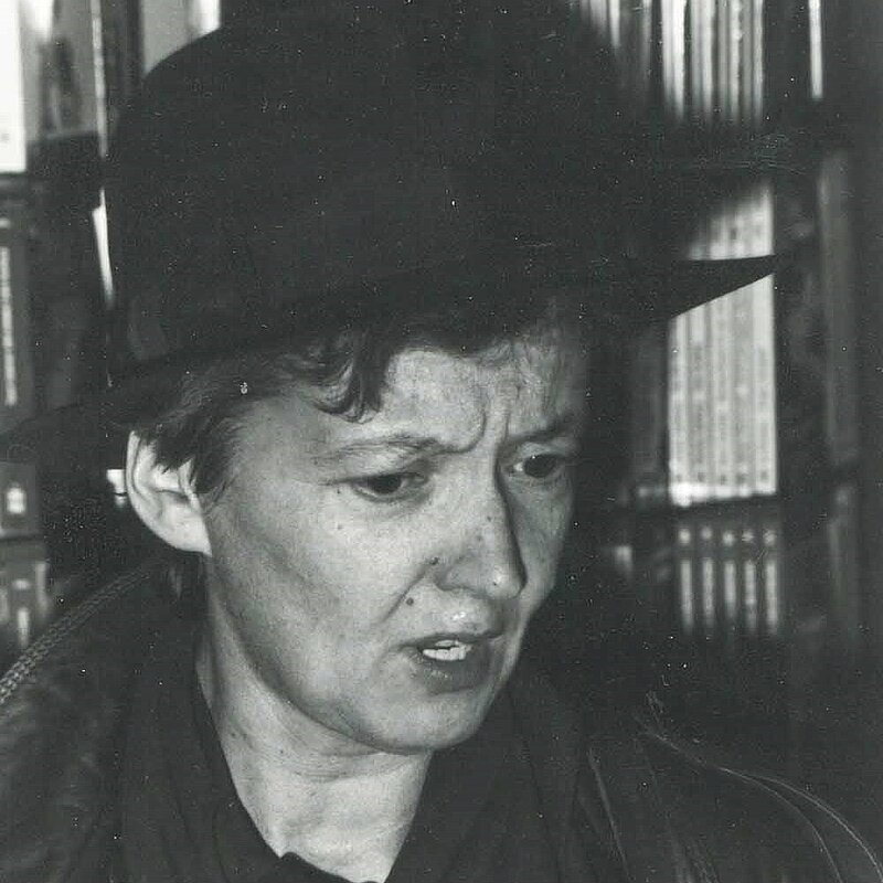 Schwarz-Weiß-Foto von Frau mit schwarzem Hut, Schal und Lederjacke 