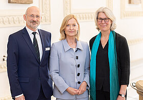Drei Personen posieren nebeneinander.