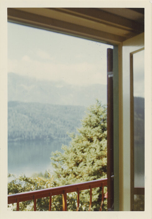 Foto aus dem Fenster mit Blick auf Balkon und Berge.