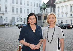 Foto von zwei Personen in Sommerkleidern am Josefsplatz in Wien.