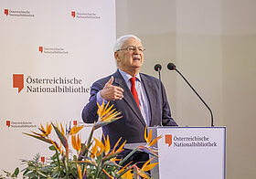 Person auf Bühne spricht in Mikro.