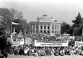 Demonstration vor altem Gebäude mit Transparenten.