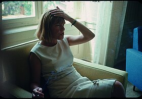 Ingeborg Bachmann sitzt in einem Fauteuil, die linke Hand auf den Kopf gelegt, nachdenklich im Gespräch