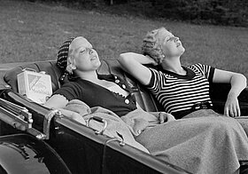 Zwei Personen sonnen sich in Cabrio.
