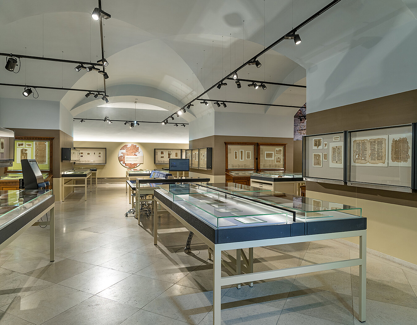 Blick in den Hauptraum des Papyrusmuseums der Österreichischen Nationalbibliothek. Die Exponate sind in Pult- und Wandvitrinen ausgestellt.