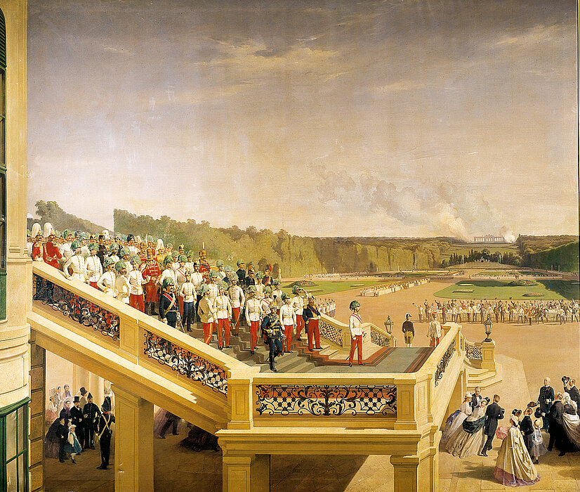 Kaiser Franz Joseph auf der Gartenstiege des Schlosses Schönbrunn mit uniformierten Männern im Hintergrund und jubelnden Menschen im Vordergrund.