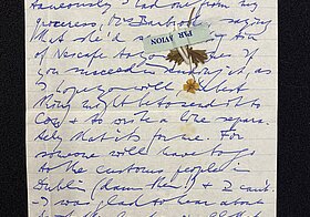 Handgeschriebener Brief mit getrockneter Blume.