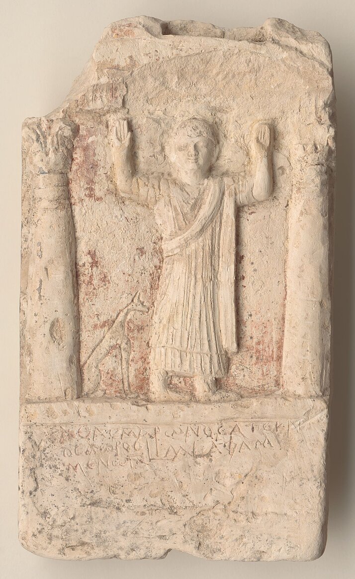 Grabstele aus Kalkstein mit der Darstellung eines Mannes, der beide Arme erhoben hat.