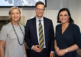 Foto von drei Personen in eleganter Kleidung. 
