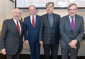 Vier Männer stehen nebeneinder