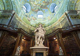 Statue von Karl VI. im Zentrum eines barocken Bibliothekssaal