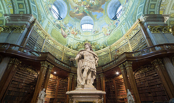 Statue von Karl VI. im Zentrum eines barocken Bibliothekssaal