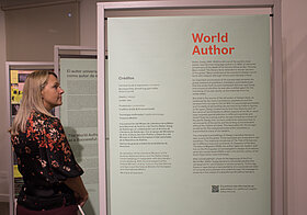 Frau vor der "Welt-Autor"-Schautafel