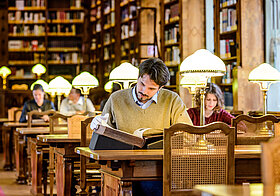 Personen lesen in einem barocken Bibliothekssaal